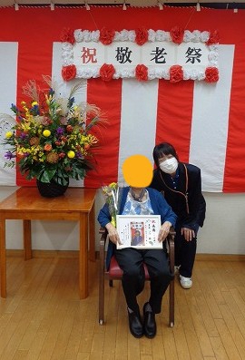 賀寿を迎えられたお客様の表彰。写真を添えた賞状をお受け取りいただきました。