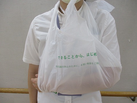 ビニール袋で作った三角巾です。ビニール袋の両端を切り取り輪っかにして腕を吊るしています。