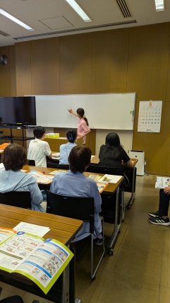 ホワイトボードに図を描いて説明をしているところ